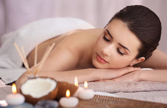 Bild von Frau liegt auf Handtuch bei Entspannung mit Kerzen Kokosnuss und Make-up 